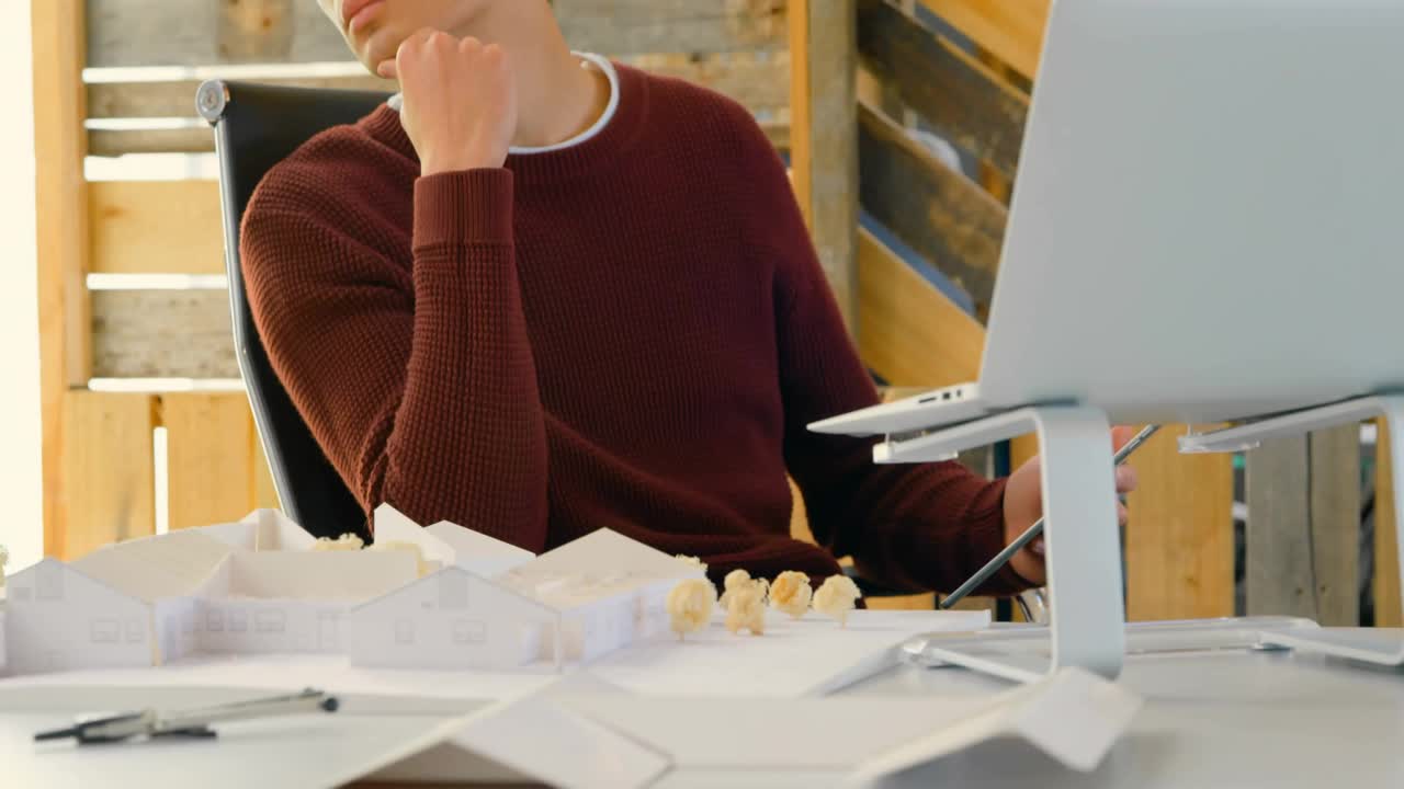 Designer gazing at drafting desk in loft as social media icons clustering showing engagement growth