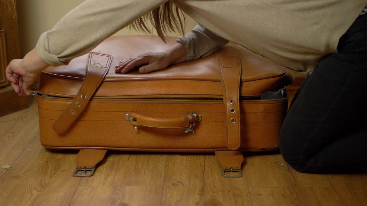 오래 된 갈색 가방 와이드 샷 압축을 풀고 여자