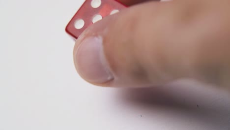 man plays with white spots dices on light background