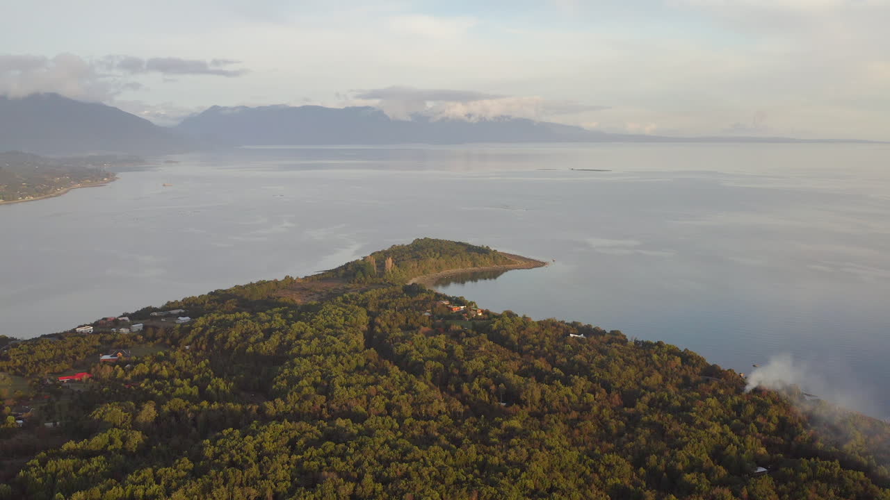 carretera del sur, localidad pichiquillaipe, bordeando la costa con un denso bosque nativo y un mar lleno de rocas