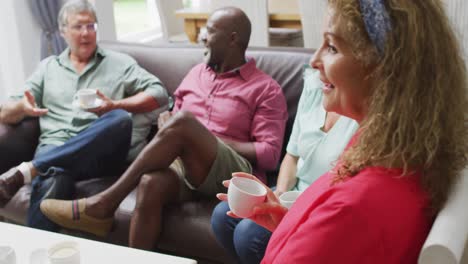 Animation-of-happy-diverse-female-and-male-senior-friends-drinking-coffee-at-home