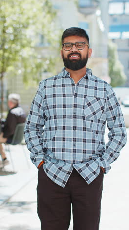 Happy-Indian-man-smiling-turning-looking-at-camera-resting-good-news-feel-satisfied-on-city-street