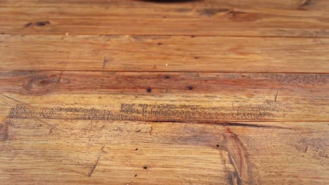 cerca de una hamburguesa de cordero con papas fritas siendo removida de la mesa de madera donde estaba