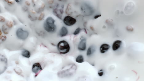 Müsli-Beeren-Mischprozess,-Draufsicht.-Müsli,-Schwimmende-Kalziummilch