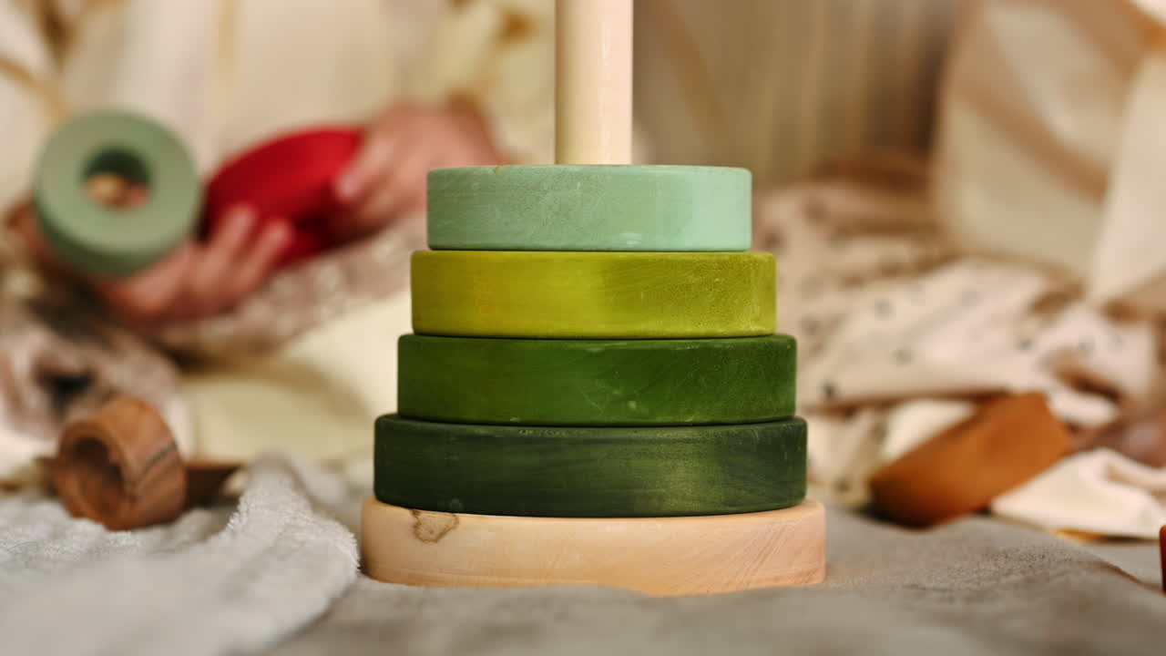 Two little girls playing with vibrantly colored blocks of a large wooden pyramid. Ecological and sustainability concept