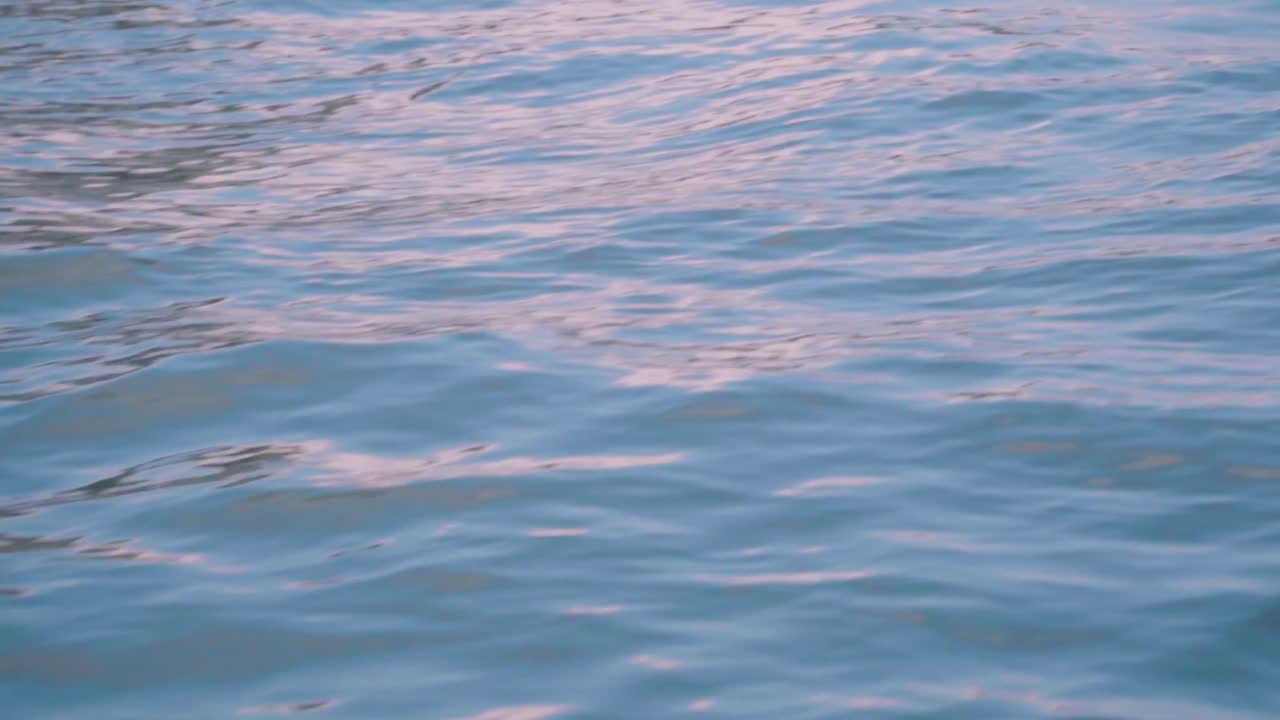 Close-up view of freshwater flowing with ripples and sun glare on the ...