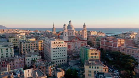 Sunset-aerial-toward-grand-basilica-of-Santa-Maria-Assunta-of-Carignano,-Genoa