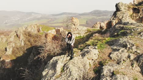 mujer caucásica atractiva fotografiando montañas con dslr y bailando emocionada. fotografía de viaje al aire libre concepto