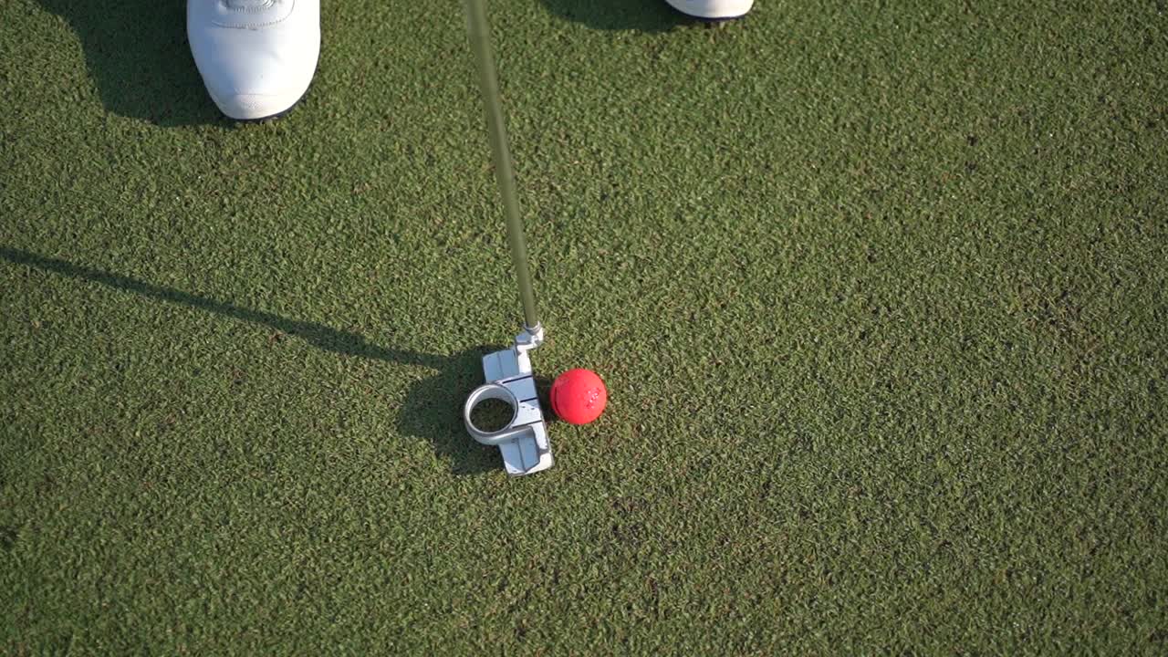 공에 가까이 가서, 골퍼는 막대기로 공을 때립니다.