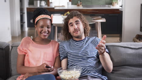 una pareja diversa disfruta de un momento relajado en casa viendo una película