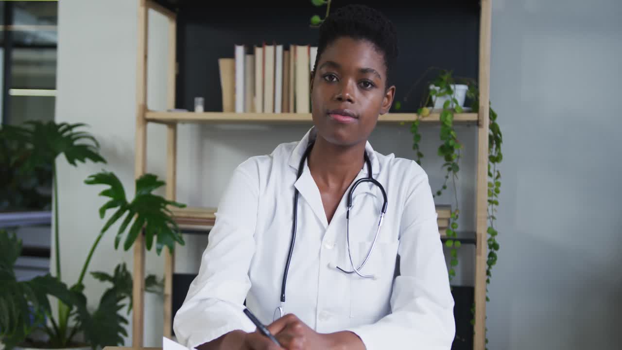 retrato de una doctora afroamericana que tiene un chat de video escuchando y escribiendo notas