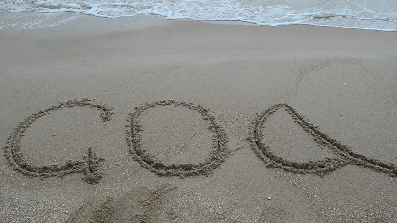 Goa title on the sand beach near the ocean. Shooting on the beach