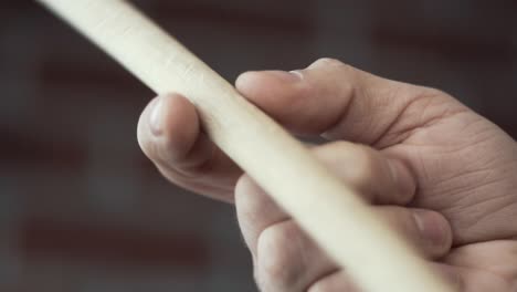 hand holding a wooden drum stick