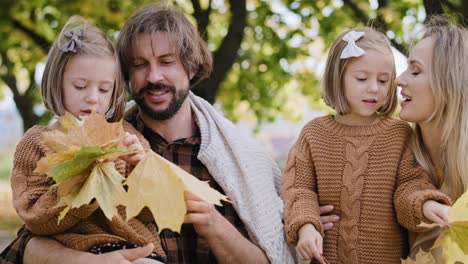 familia recogiendo hojas en la temporada de otoño