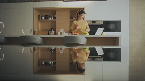 woman preparing and eating breakfast in a modern kitchen