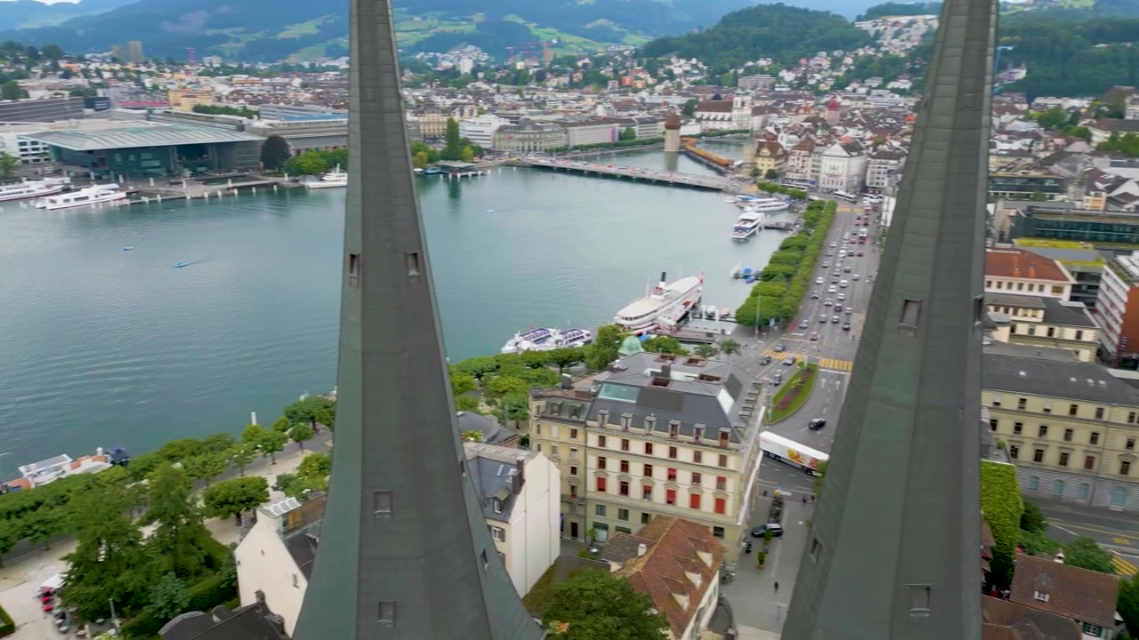 Vídeo de drone 4K do Hotel Parkhaus National e da Igreja Hofkirche St. Leodegar no Lago Lucerna em Lucerna, Suíça.