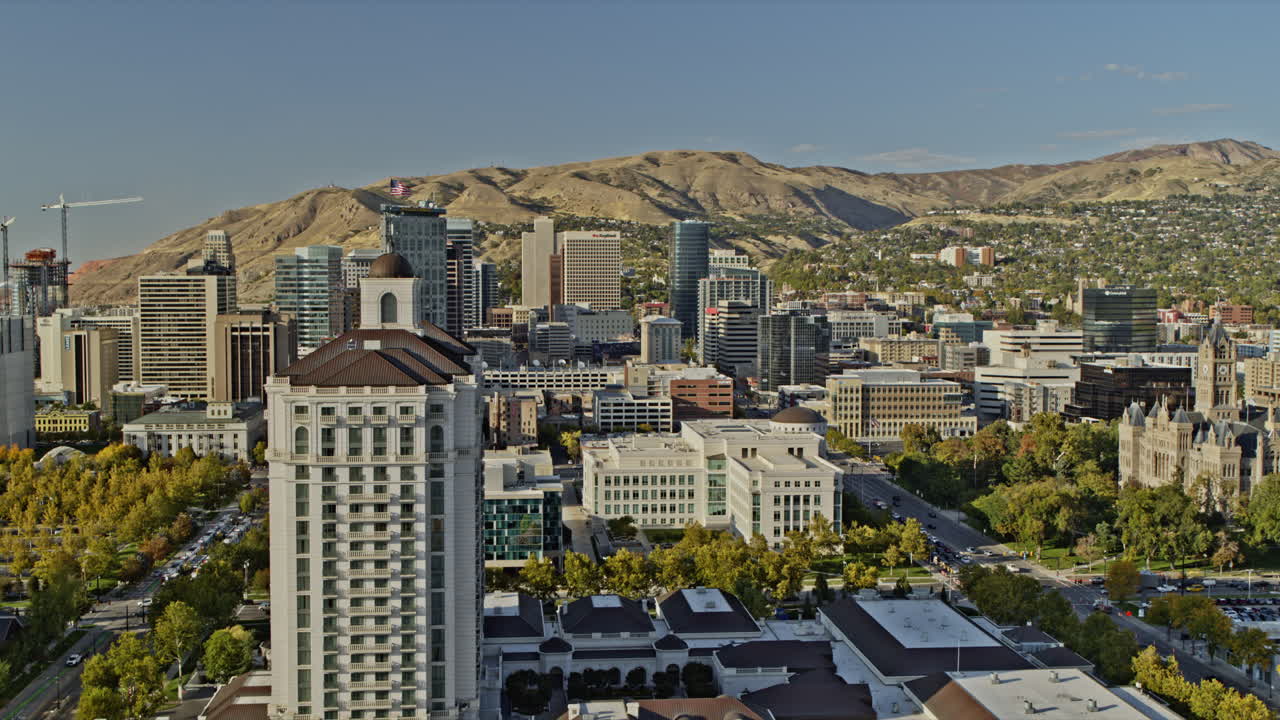 솔트레이크시티 (salt lake city, utah) 에어리얼 v18은 시내를 지나 캐피톨 빌딩으로 이어지는 스테이트 스트리트를 향해 날아다니며 도시 풍경과 산 풍경을 포착합니다.