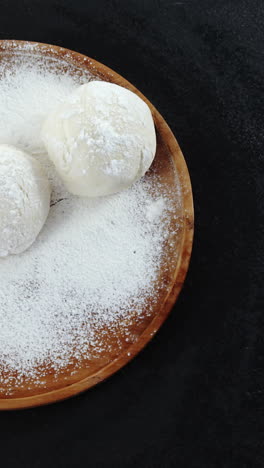 rolling pin with pizza dough and flour on plate