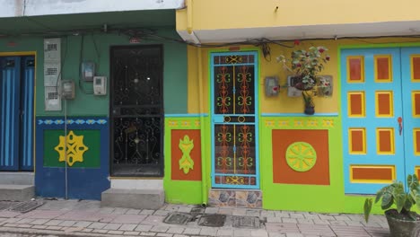 vibrant, colorful facade of a house in guatapé, colombia with potted plants and detailed artwork