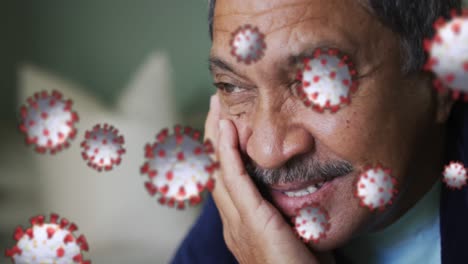 Multiple-covid-19-cells-floating-against-close-up-of-african-american-man-smiling