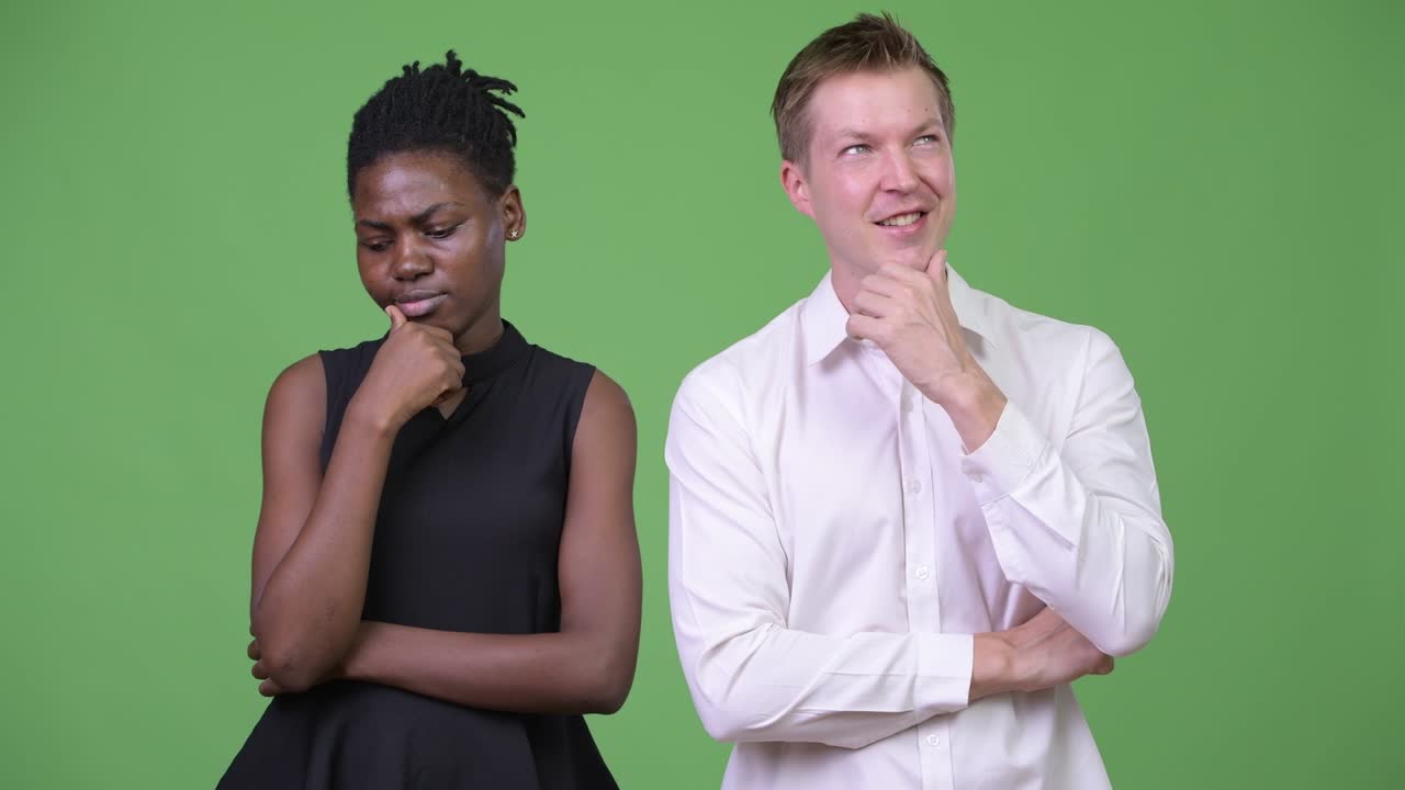 Two young multi-ethnic business couple thinking together