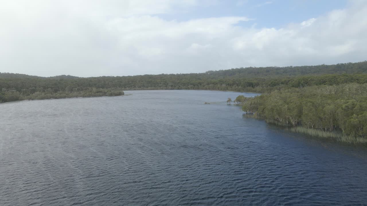 vuele sobre las aguas tranquilas de los densos bosques costeros del lago marrón en north stradbroke island, sureste de queensland, australia