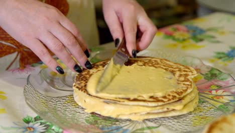 cooking. a woman lays the custard on a layer cake