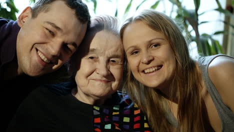 Young-man-and-woman-kissing-grandmother-on-cheeks