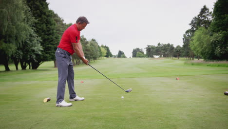 Reifer-Männlicher-Golfer-Schlägt-Mit-Dem-Driver-Den-Abschlag-Entlang-Des-Fairways