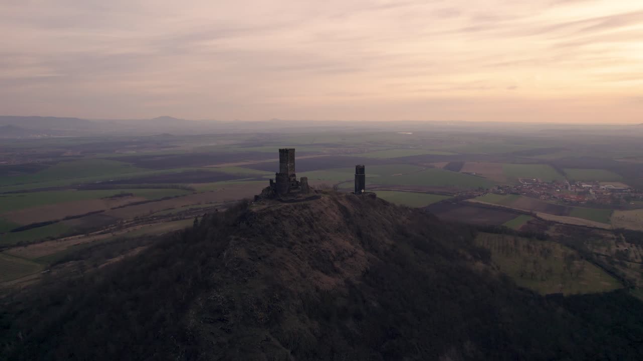 torres del castillo medieval en la cima de la colina al anochecer, toma cinematográfica del establecimiento de drones