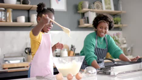 Feliz-Madre-E-Hija-Afroamericana-Preparando-Masa-En-Un-Tazón-En-La-Cocina,-Cámara-Lenta