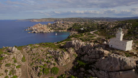 vista aérea descubriendo el faro de cabo testa en la isla de cerdeña y viendo la hermosa costa y sus pequeñas playas