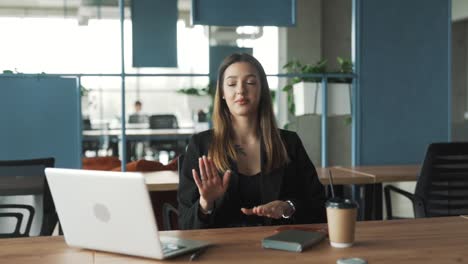 beautiful-young-woman-in-the-office-at-her-workspace-turns-on-music-and-starts-dancing