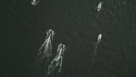 two boats sailing on calm, dark water captured from an aerial view