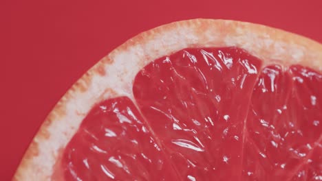 video of sliced red grapefruit with copy space over red background