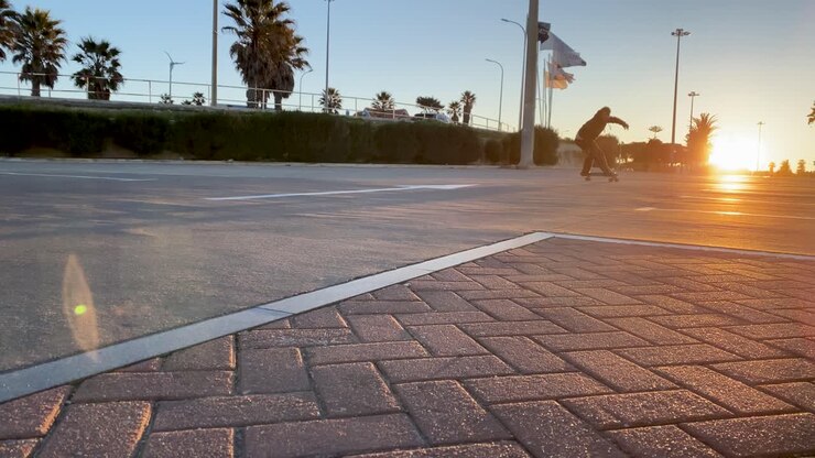 A skater carves through the streets at sunrise, his silhouette striking against the golden sun rays
