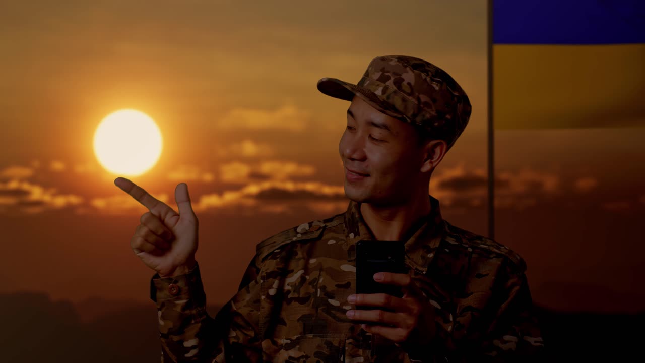 해가 지는 동안 스마트폰을 들고 미소 짓는 군인