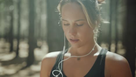 caucasian female running in forest listening to music with earphones