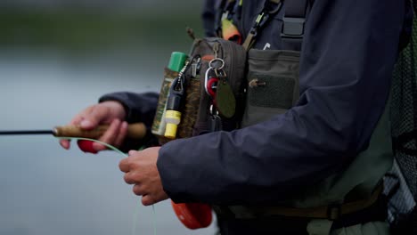 Close-up-of-equipment-and-hands-of-young-man-casting-fly-fishing-rod