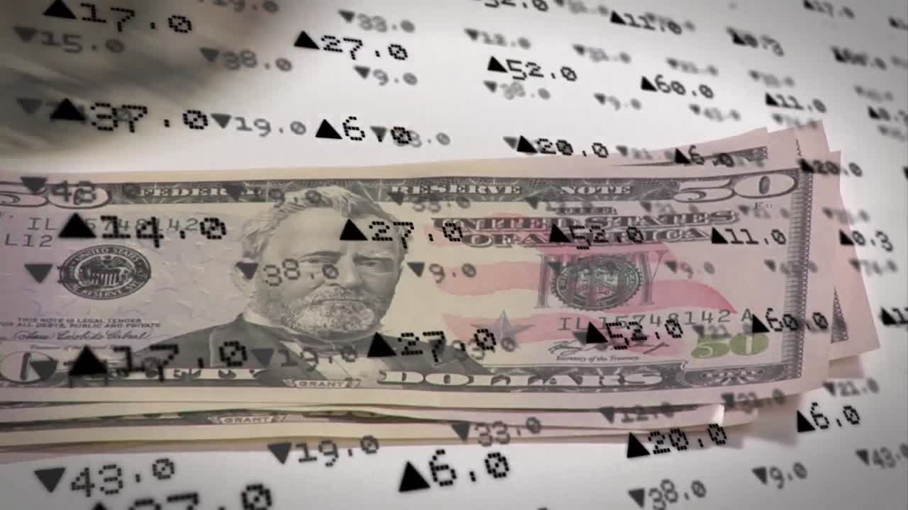 animación del procesamiento de datos del mercado de valores en primer plano de la mano manteniendo billetes de dólar en la superficie gris
