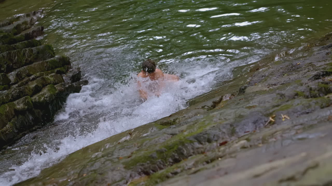 persona nadando en una cascada