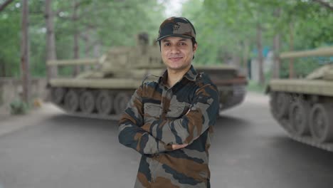 retrato de un feliz hombre del ejército indio de pie con las manos cruzadas