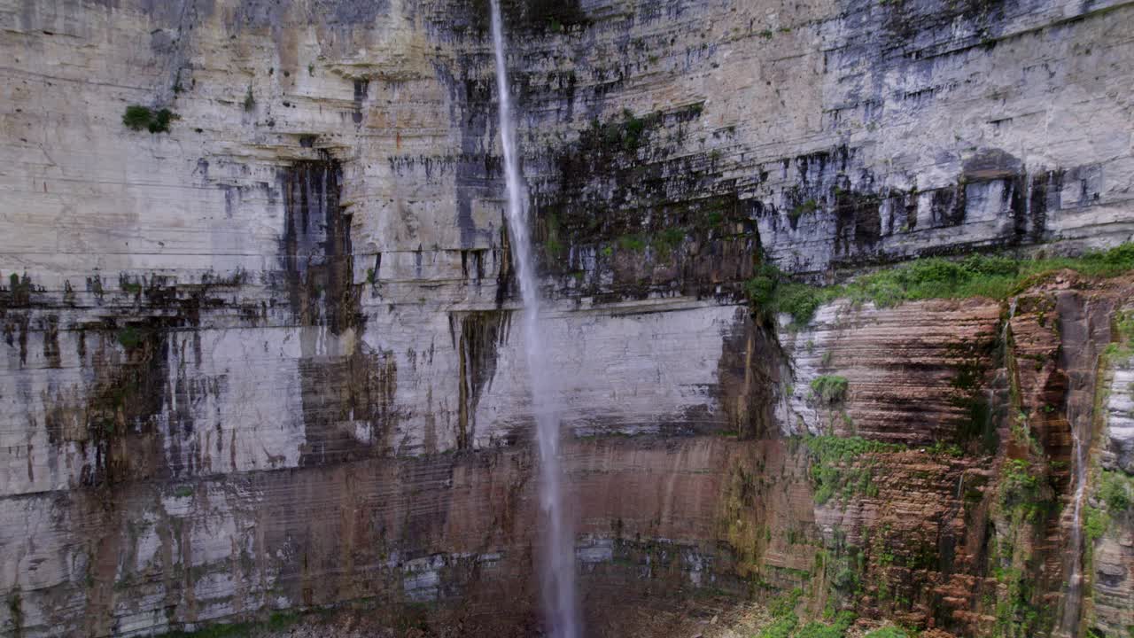 un dron captura un primer plano de una cascada que fluye por una montaña boscosa en georgia, europa
