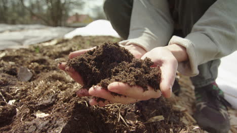 closeup reveal - healthy compost soil is lifted into shot and inspected