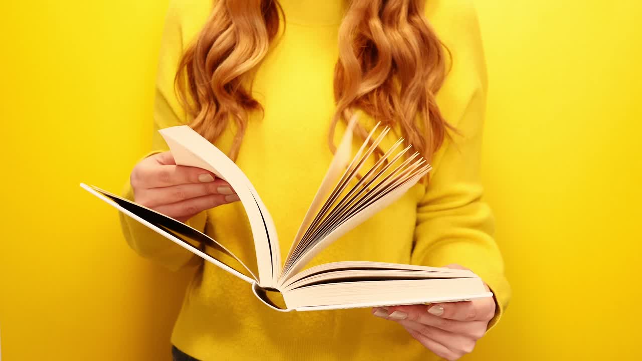 mujer de pelo rojo leyendo un libro aislado de fondo amarillo