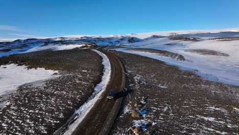a car drives on a dirt road through a vast snowy winter landscape