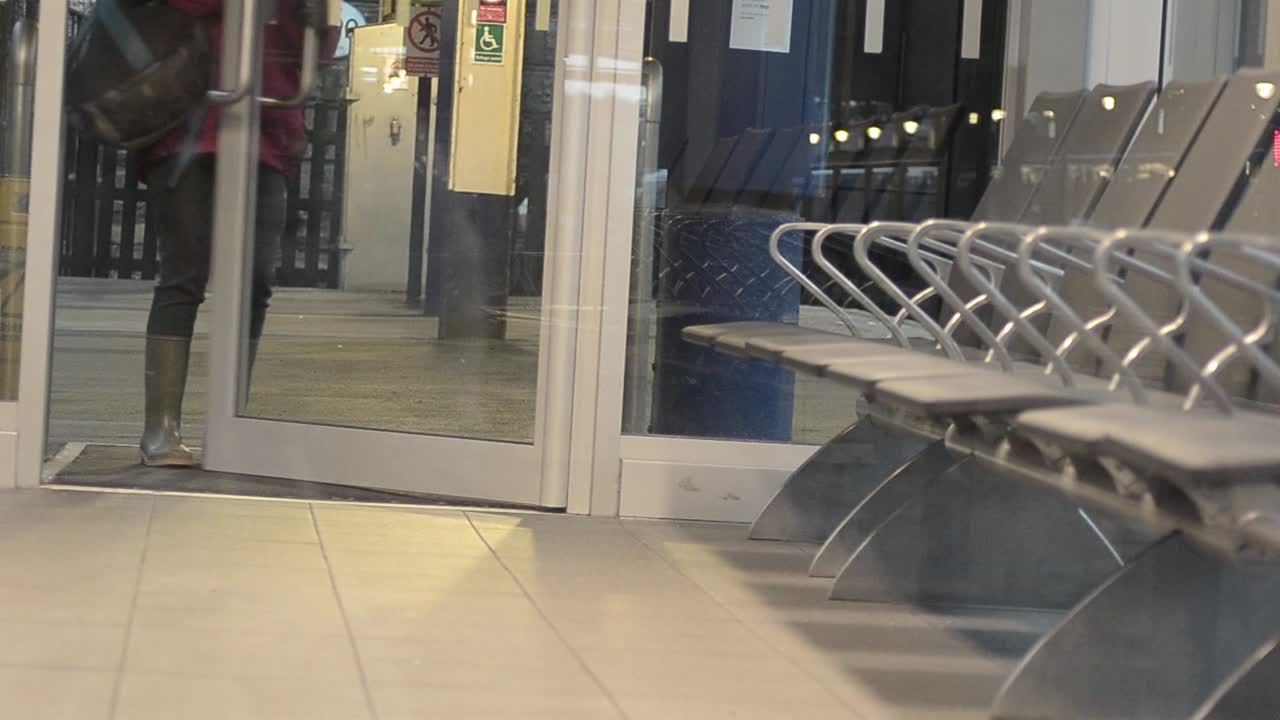 여자는 기차역의 빈 대기실에 들어간다