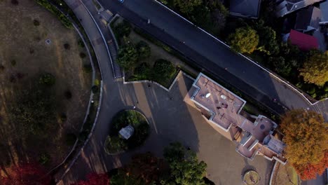 A-curved-road-and-building-with-autumn-trees-at-dusk,-aerial-view