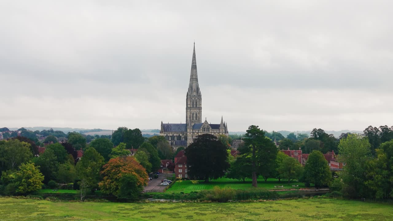 Veduta aerea con drone della Cattedrale di Salisbury, vista attraverso gli storici prati acquatici a Salisbury, Wiltshire, Inghilterra. Iconica cattedrale medievale con la guglia della chiesa più alta del Regno Unito che si erge a