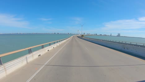 pov thru rear window while driving up the bridge on queen isabella causeway over the shipping lane on the laguna madre at south padre island, texas